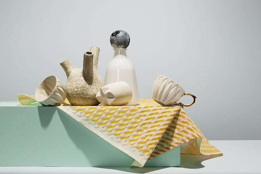Collection of ceramics, glass and textiles sit on turquoise box
